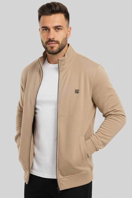 Cardigan beige da uomo con stemma e cerniera.