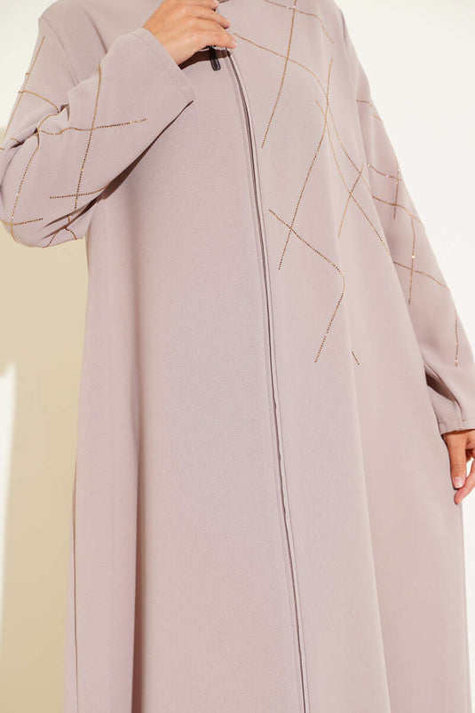 Abaya beige ornée de motifs baklava et dotée d'une fermeture éclair.