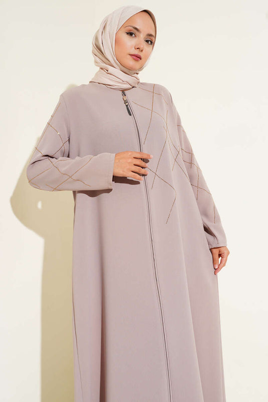 Abaya beige ornée de motifs baklava et dotée d'une fermeture éclair.