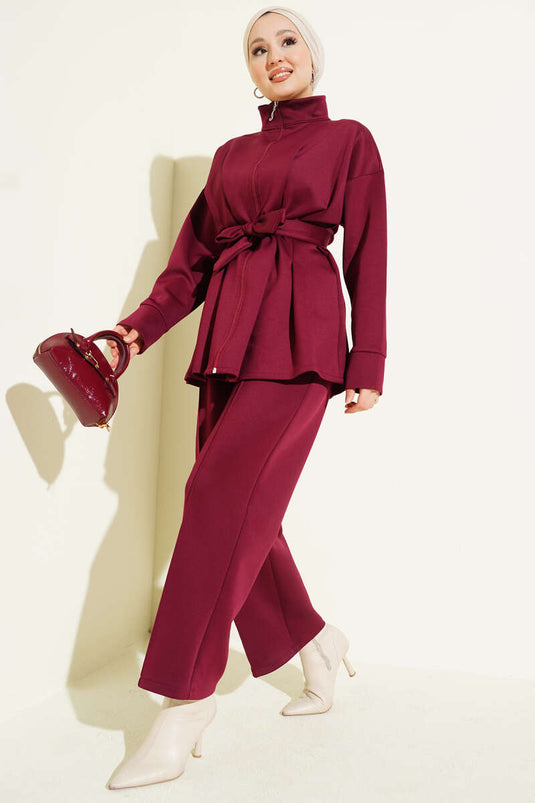 Combinaison deux pièces bordeaux en néoprène, cintrée à la taille et ceinturée.