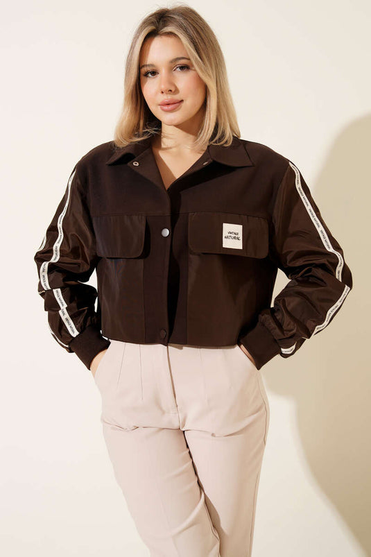 سترة بجيوب مع شريط مكتوب باللون البني