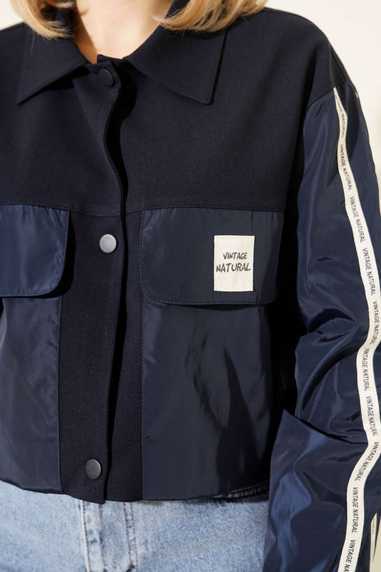 Chaqueta azul marino con bolsillos y cinta con texto