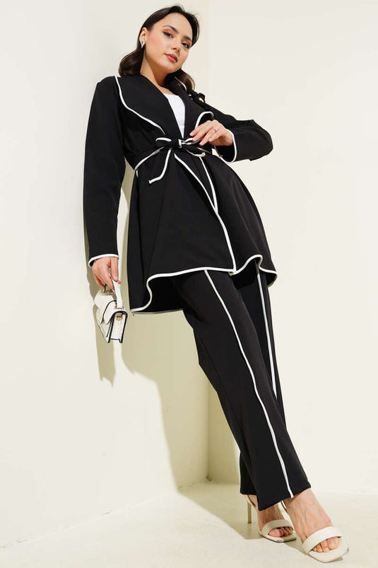 Costume deux pièces à passepoil et accessoire floral noir