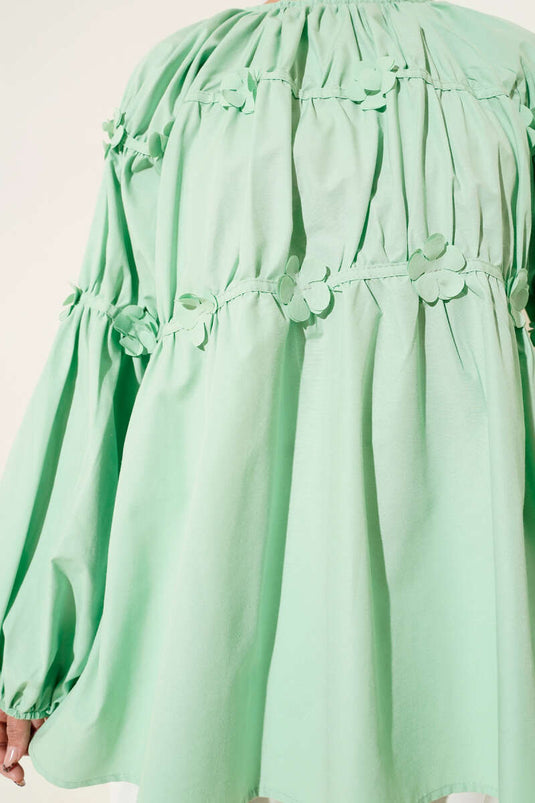 تونيك أخضر بأكمام مرنة وتفاصيل زهور