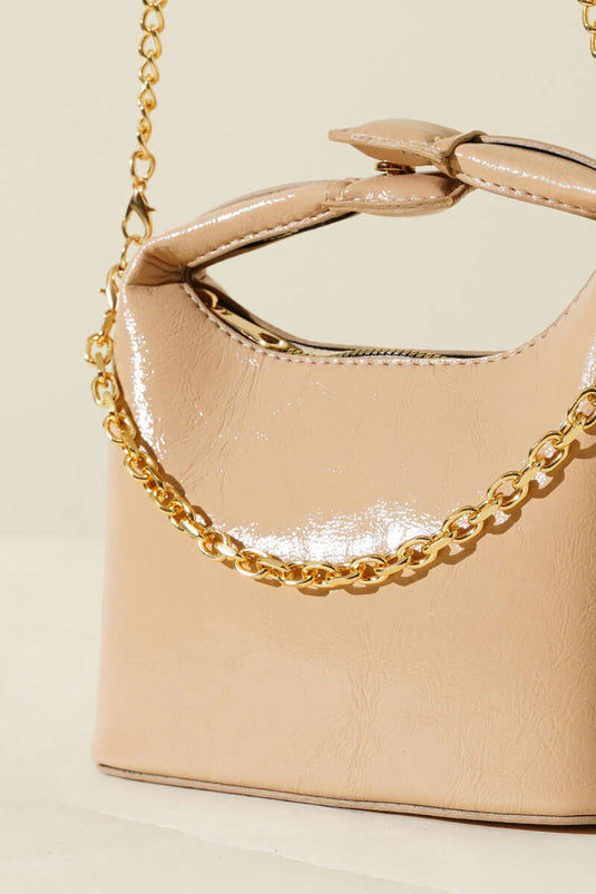 Bolso de charol con correa de cadena y asa a presión en color beige