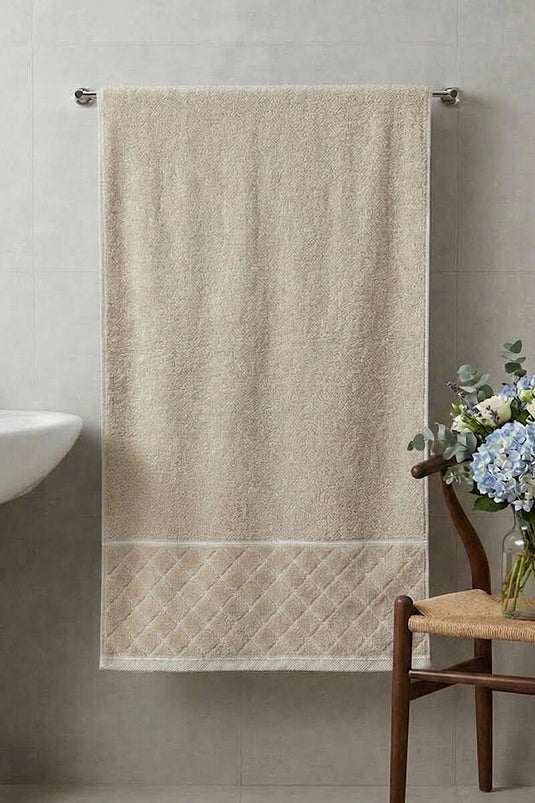 Asciugamano da bagno beige con dettagli a strisce e motivo a disegni