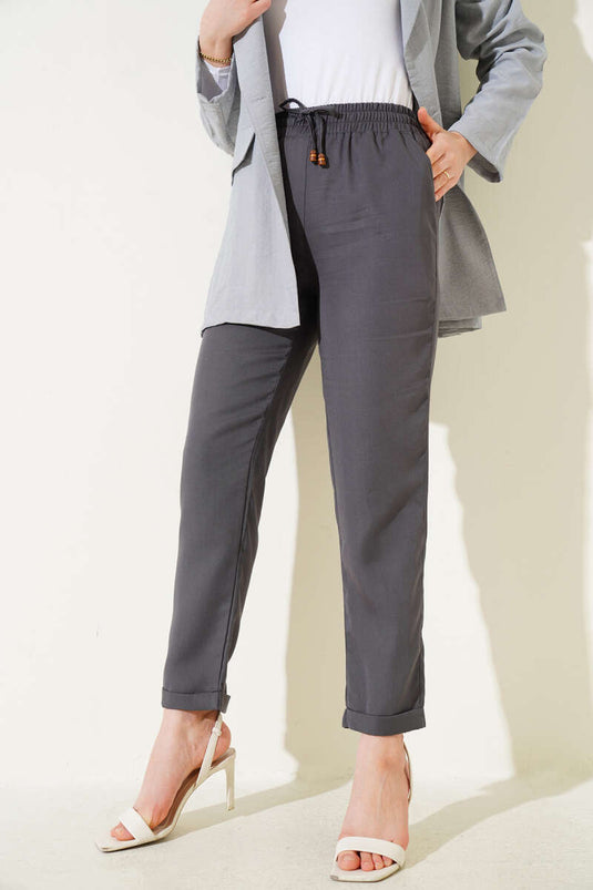 Pantalon à taille élastique en tissu gris foncé avec des jambes larges