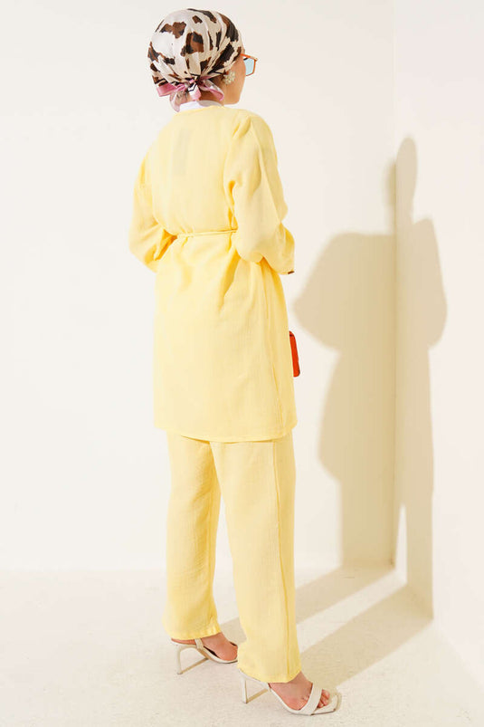 طقم من قطعتين من قماش الموسلين الأصفر، مزين بأزرار وحزام برباط