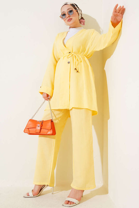 طقم من قطعتين من قماش الموسلين الأصفر، مزين بأزرار وحزام برباط