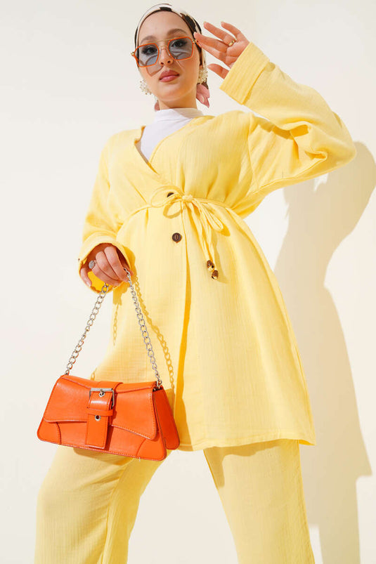 طقم من قطعتين من قماش الموسلين الأصفر، مزين بأزرار وحزام برباط