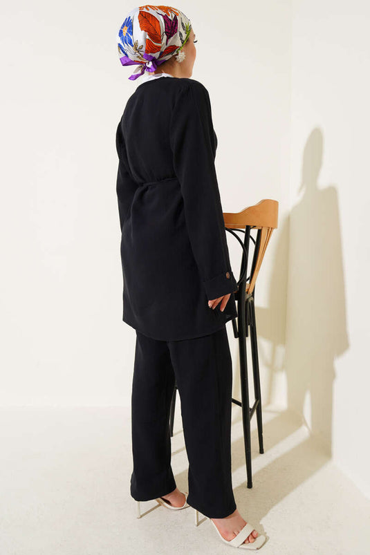 طقم من قطعتين من قماش الموسلين الأسود، مزود بأزرار ورباط.