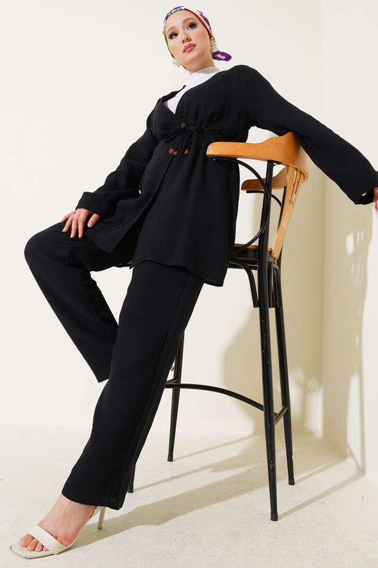 طقم من قطعتين من قماش الموسلين الأسود، مزود بأزرار ورباط.