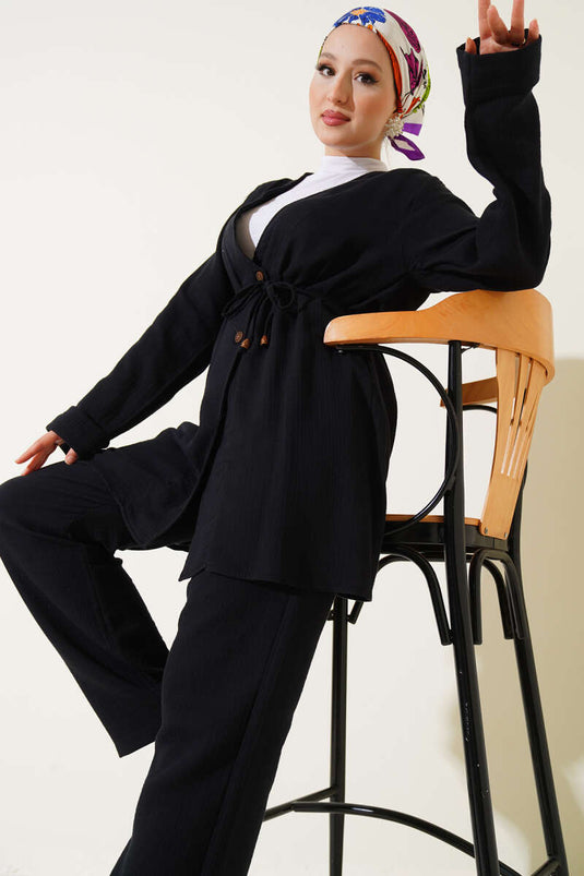 طقم من قطعتين من قماش الموسلين الأسود، مزود بأزرار ورباط.