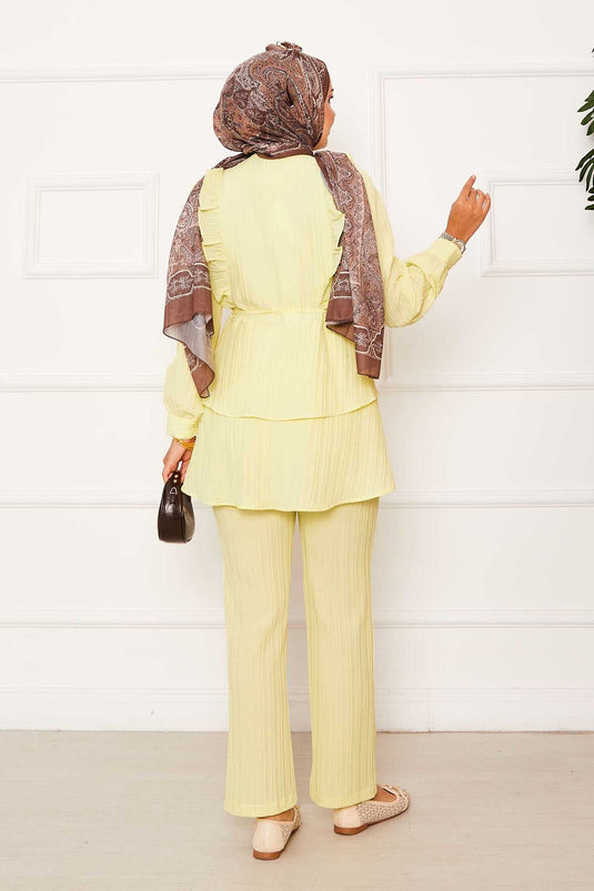 Costume deux pièces jaune avec volants et détails volantés sur la jupe