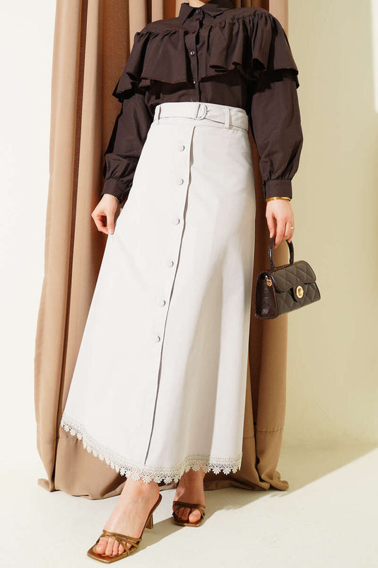 Rockspitze mit Spitzenbesatz und Knopfdetail Stein