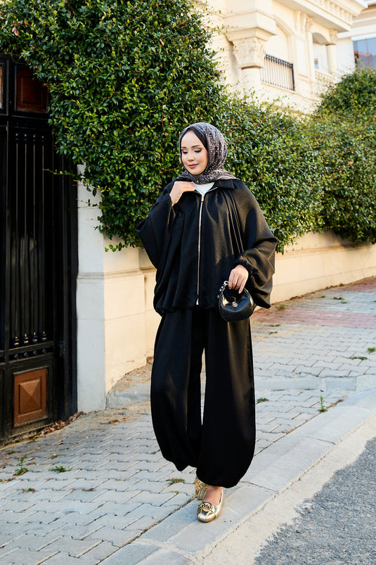بدلة سوداء فضفاضة من قطعتين بأكمام خفاش وسحاب