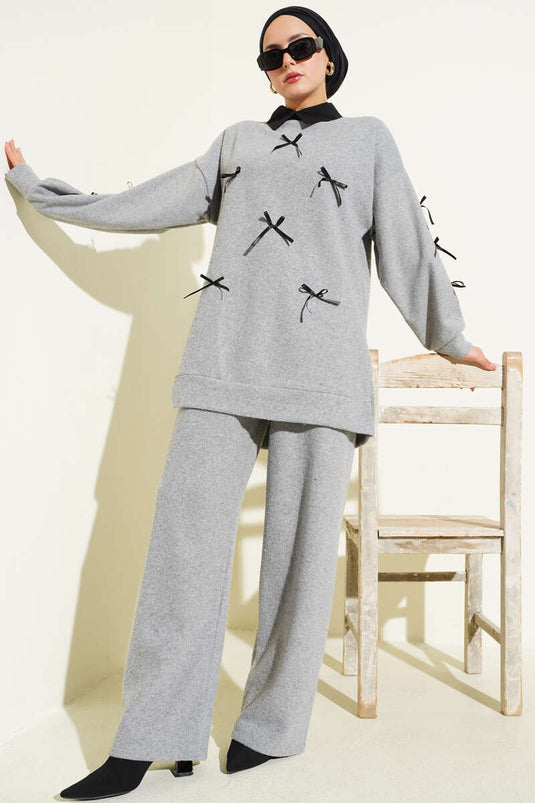 Ensemble deux pièces gris orné d'un nœud papillon.