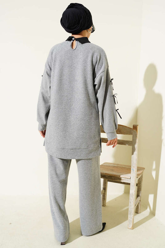 Ensemble deux pièces gris orné d'un nœud papillon.