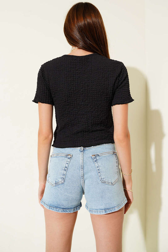 Zwarte blouse met wafelpatroon en strik aan de voorkant