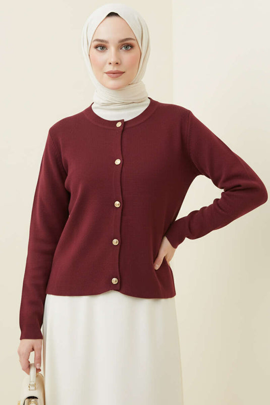 Gilet court en maille bordeaux, orné de boutons dorés.