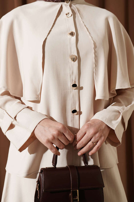 Ensemble beige avec jupe en tensel et cape à boutons dorés