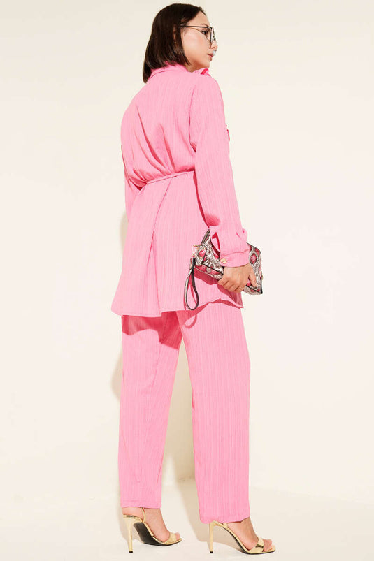 Ensemble deux pièces rose avec boutons dorés et volants en forme de V