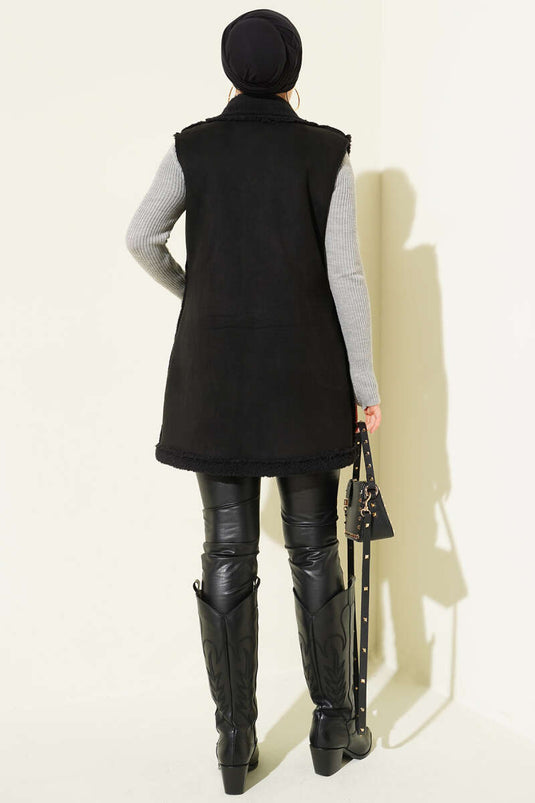 Gilet en daim noir, doublé de fourrure et doté de poches.