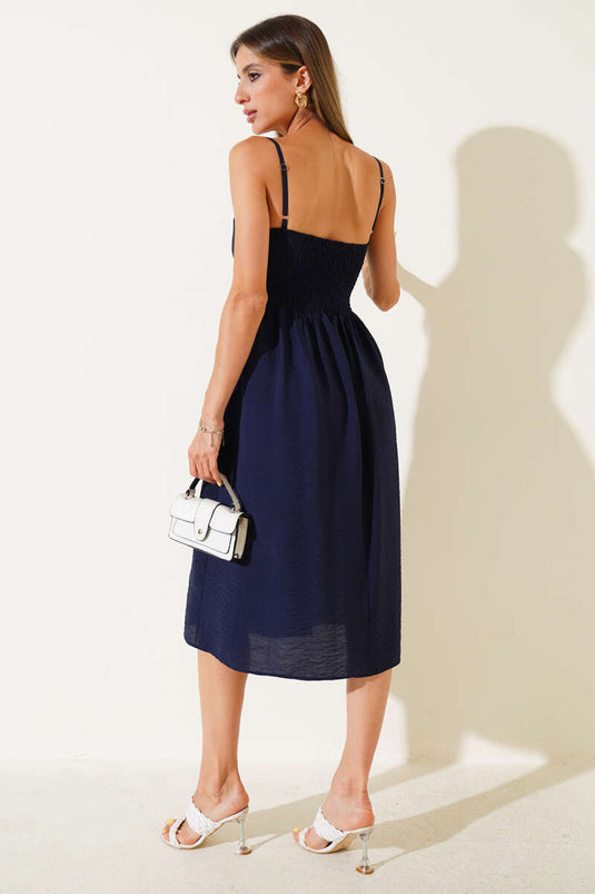 فستان فضفاض ذو حمالات رفيعة باللون الأزرق الداكن.