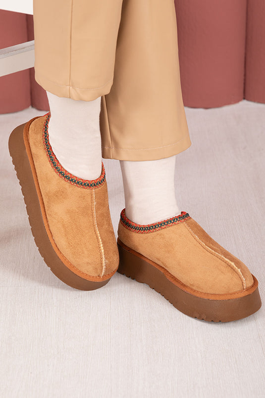 Bottes courtes beiges à semelles épaisses et doublure en fourrure.