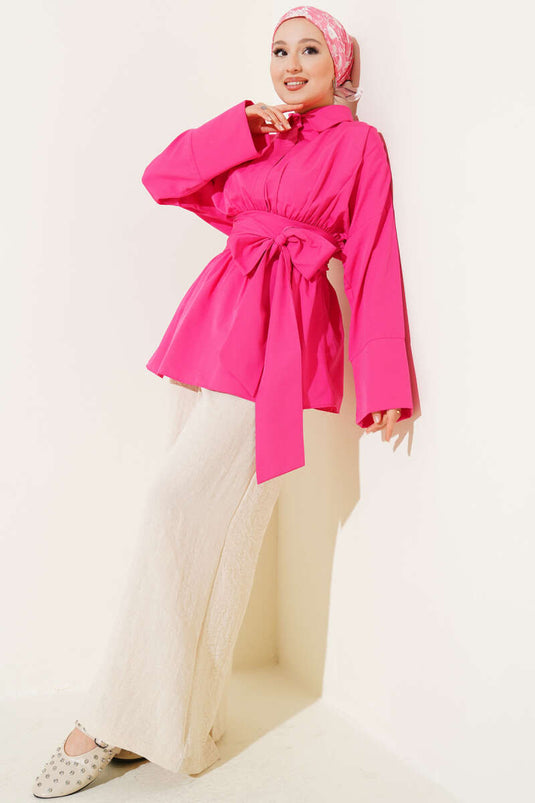 Tunique fuchsia à ceinture intégrée et froncée sur le devant.