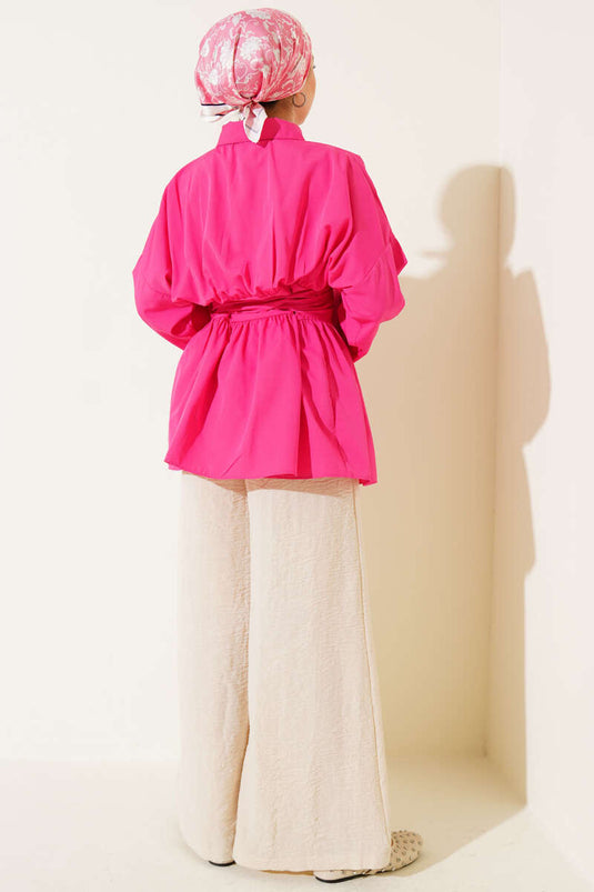 Tunique fuchsia à ceinture intégrée et froncée sur le devant.