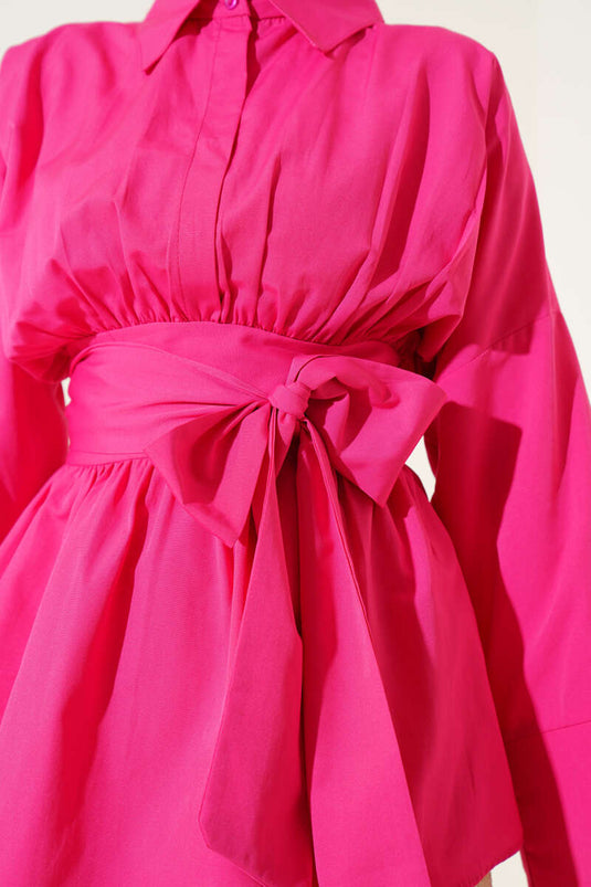Tunique fuchsia à ceinture intégrée et froncée sur le devant.