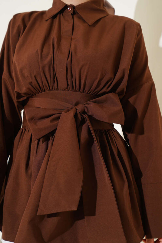 Tunique marron à ceinture intégrée et froncée sur le devant.