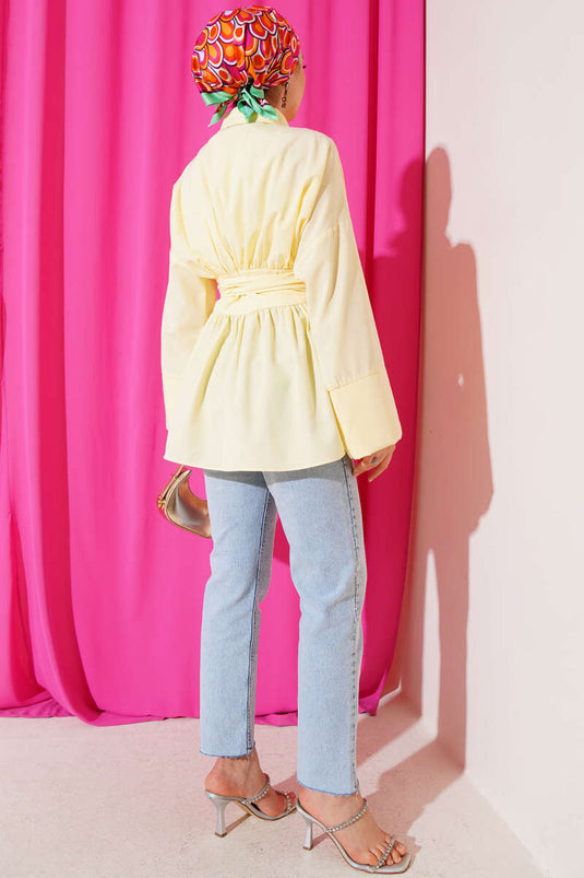 Tunique jaune à ceinture intégrée et froncée sur le devant.