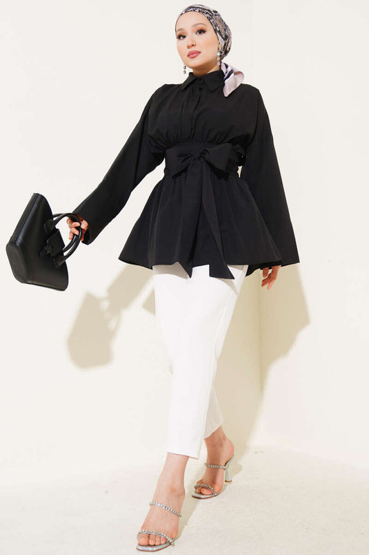 Tunique noire à ceinture intégrée et froncée sur le devant.