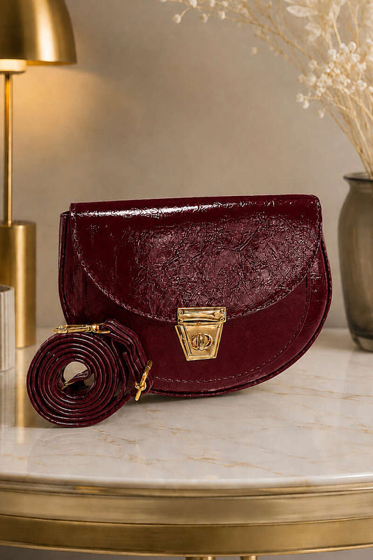 Sac ovale en cuir verni avec détail de fermeture, bordeaux