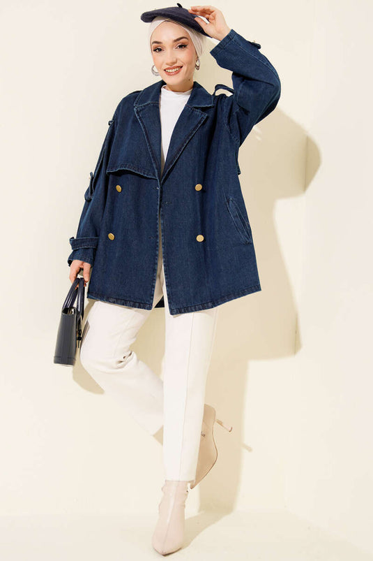 Trench-coat en denim bleu avec épaulettes et ceinture.