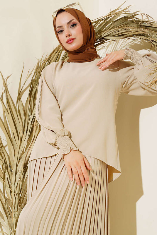 Tailleur en crêpe beige orné de pierres sur les côtés des manches