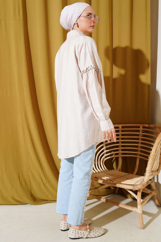 Chemise beige ornée de perles sur les manches
