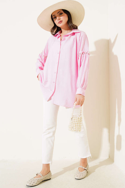 Chemise rose avec détails nacrés sur les manches