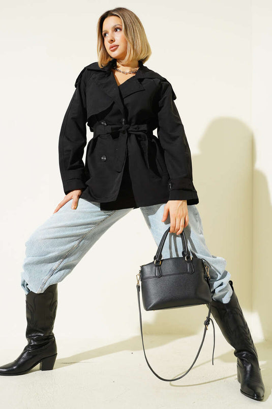 معطف قصير أسود اللون، ذو صفين من الأزرار وحزام.