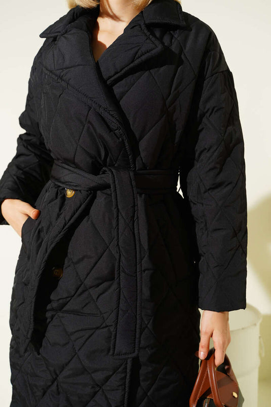 معطف أسود مبطن بحزام، ذو صفين من الأزرار.