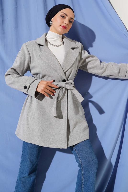 معطف قصير من الكشمير، رمادي اللون، بياقة مزدوجة الصدر وتفاصيل حزام.