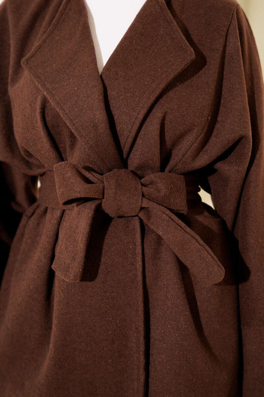 Veste croisée en cachemire marron avec ceinture.