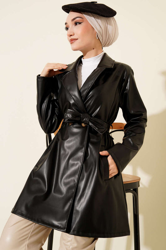 Trench-coat court en cuir noir, croisé et ceinturé.