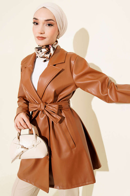 Trench-coat court en cuir beige à double boutonnage et ceinture.