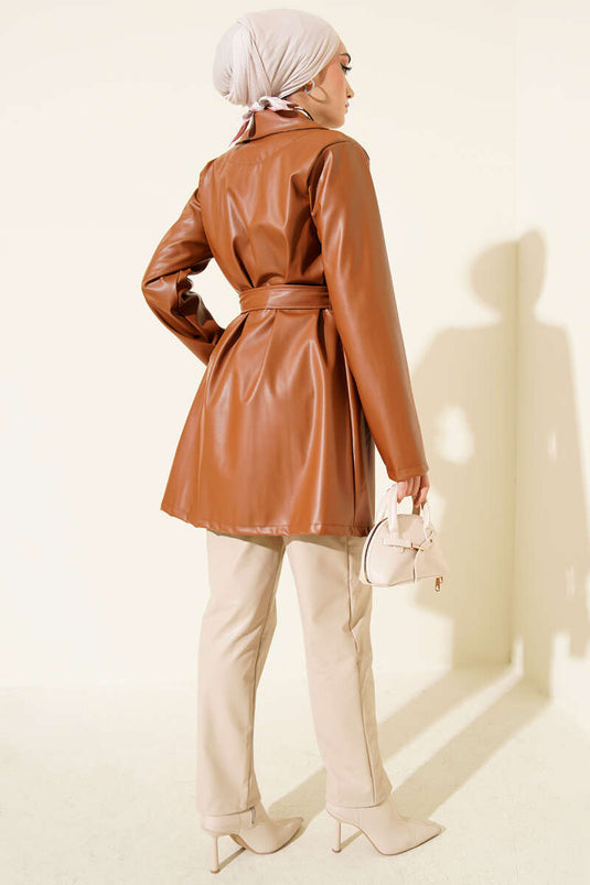 Trench-coat court en cuir beige à double boutonnage et ceinture.