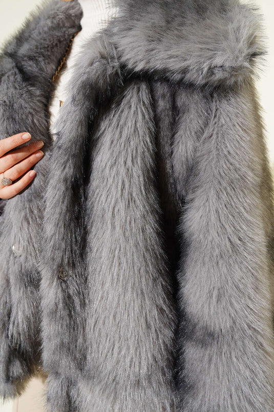 معطف فرو رمادي فضفاض ذو صفين من الأزرار وجيوب.