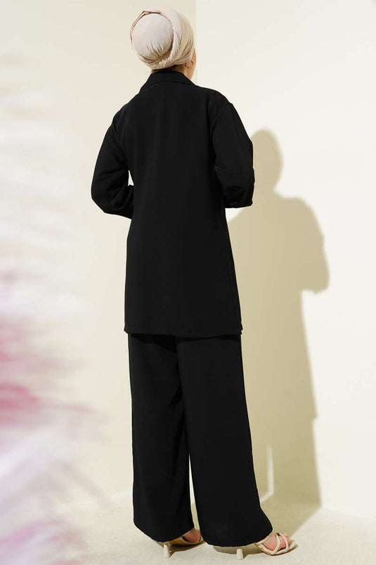 Traje negro de dos piezas con doble botonadura y lazo lateral