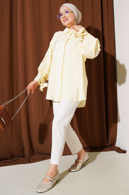 قميص أصفر بأكمام منفوخة وتفاصيل فتحات